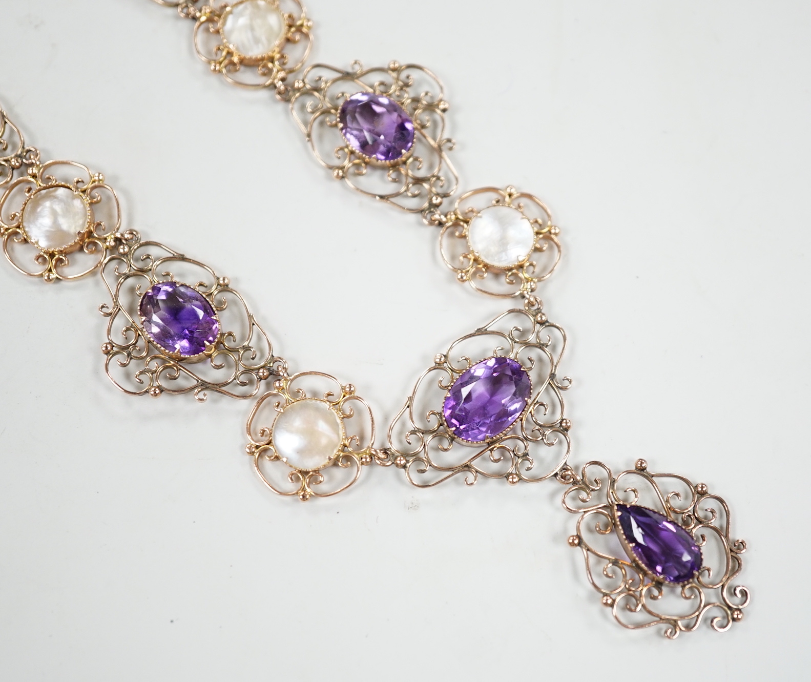 An Edwardian yellow metal, amethyst and mother-of-pearl set drop necklace, 44cm, gross weight 29.5 grams.